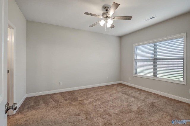 spare room featuring ceiling fan and light colored carpet