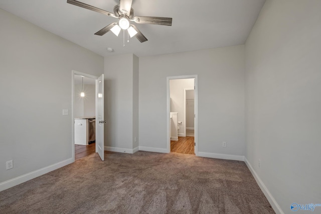 unfurnished bedroom featuring ceiling fan, ensuite bathroom, and light colored carpet