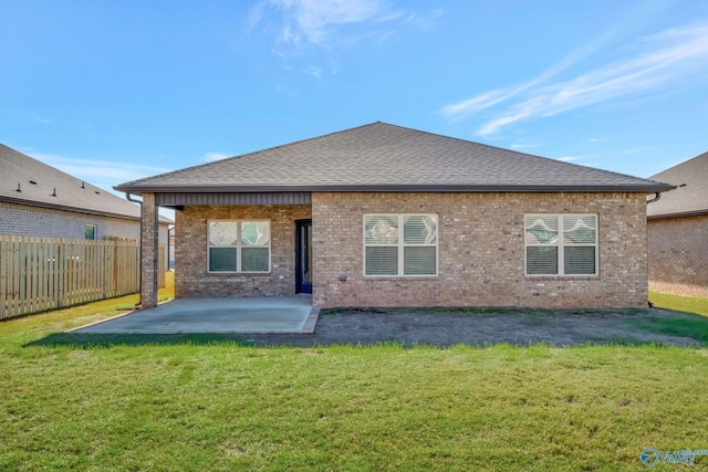 rear view of house with a patio and a lawn