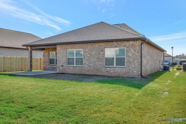 back of property featuring a patio area, a yard, and central AC