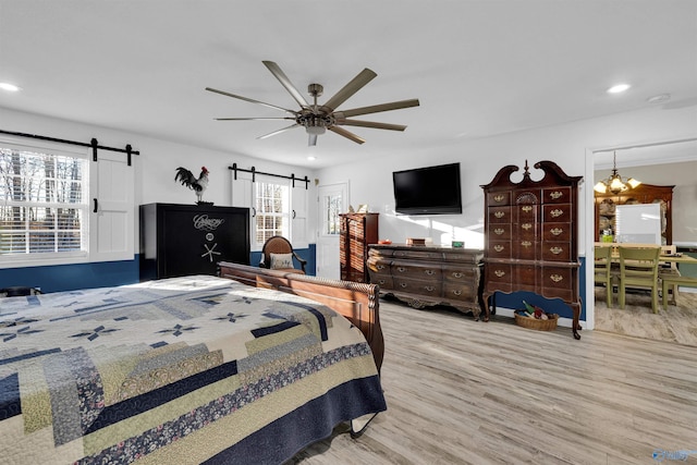 bedroom with recessed lighting, wood finished floors, ceiling fan, and a barn door