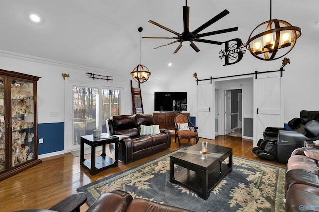 living area featuring a chandelier, a barn door, wood finished floors, and baseboards