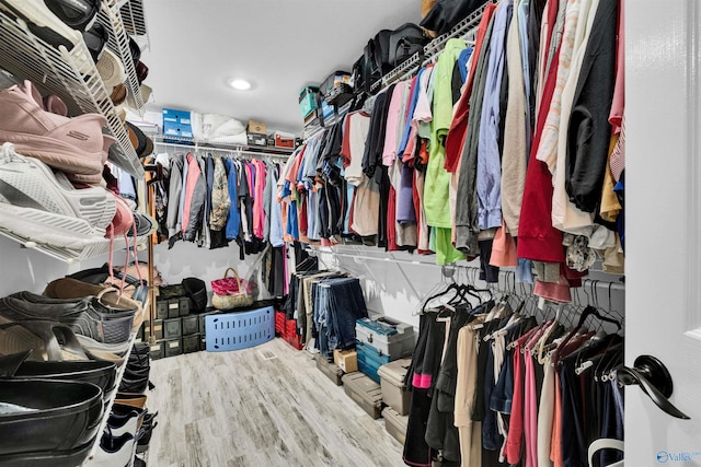 walk in closet with wood finished floors