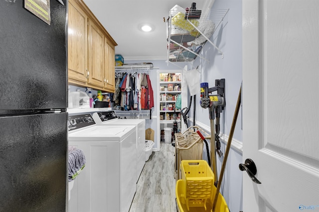 laundry room with washer and clothes dryer, light wood-type flooring, cabinet space, and crown molding