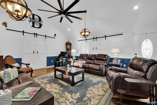 living area featuring lofted ceiling, recessed lighting, a barn door, a ceiling fan, and wood finished floors