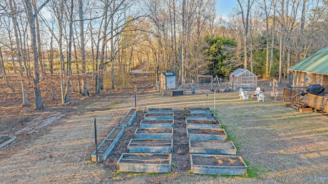 view of yard featuring an outbuilding, an exterior structure, and a vegetable garden