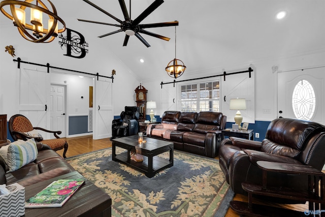 living room featuring high vaulted ceiling, a barn door, recessed lighting, wood finished floors, and a ceiling fan