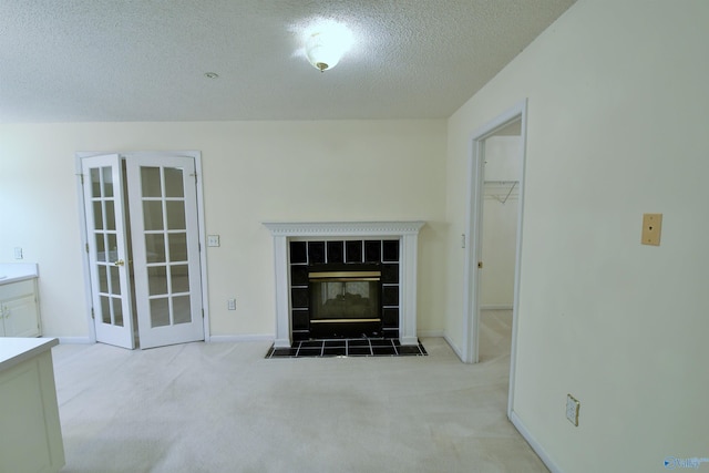 unfurnished living room featuring a textured ceiling, light carpet, and a tiled fireplace