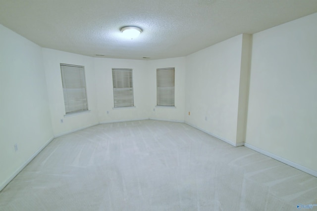 empty room featuring light colored carpet and a textured ceiling