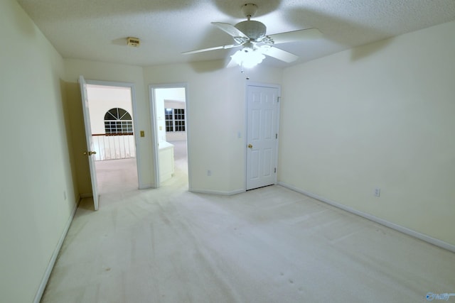 unfurnished room with light carpet, a textured ceiling, and ceiling fan