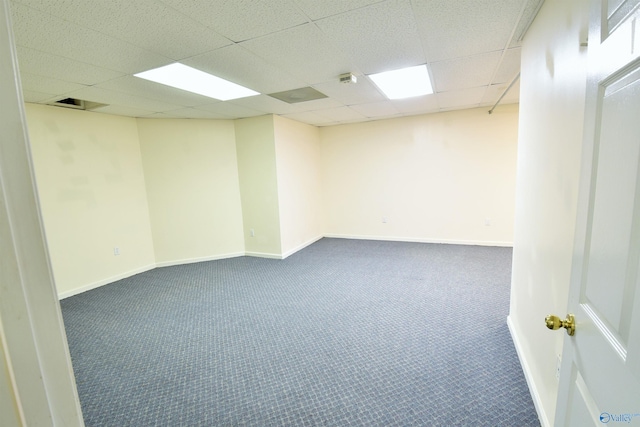 spare room featuring carpet flooring and a drop ceiling