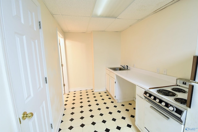 kitchen featuring a paneled ceiling, white cabinetry, white range with electric cooktop, and sink