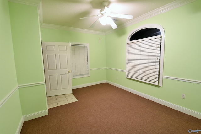 unfurnished bedroom featuring ceiling fan, dark carpet, and ornamental molding