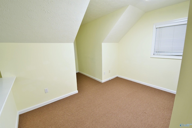 bonus room featuring a textured ceiling, light colored carpet, and lofted ceiling