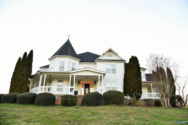 victorian house featuring a porch and a front yard