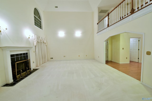 living room with a fireplace, hardwood / wood-style floors, and a high ceiling