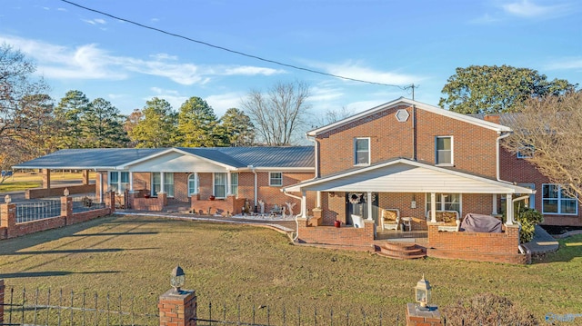 rear view of house featuring a carport, covered porch, and a yard