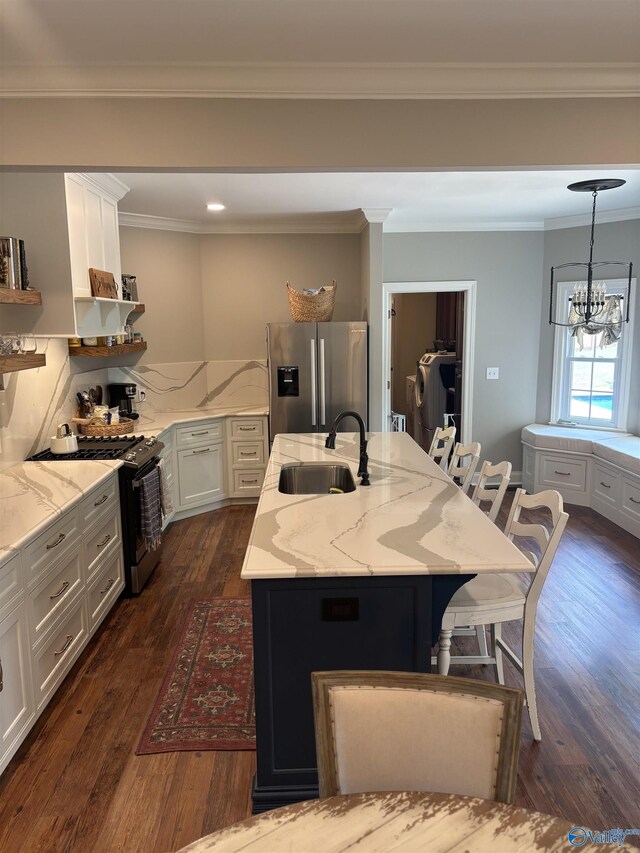 103 Covey Ln, Hazel Green, AL 35750 - kitchen with appliances with stainless steel finishes, open shelves, an island with sink, dark wood finished floors, and a kitchen bar