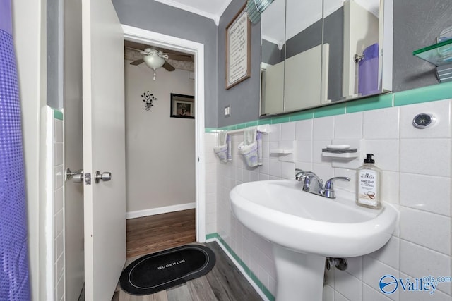 bathroom with ceiling fan, tile walls, hardwood / wood-style flooring, and ornamental molding