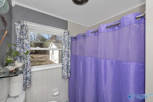 bathroom featuring toilet, tile walls, ornamental molding, and curtained shower