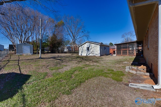 view of yard with a sunroom and a storage shed