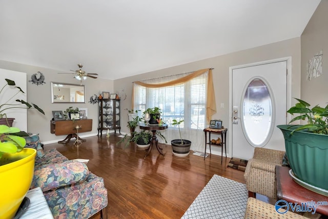 living room featuring dark wood-type flooring and ceiling fan