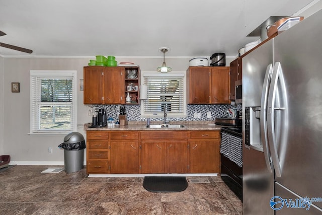 kitchen featuring stainless steel refrigerator with ice dispenser, black electric range, backsplash, hanging light fixtures, and sink