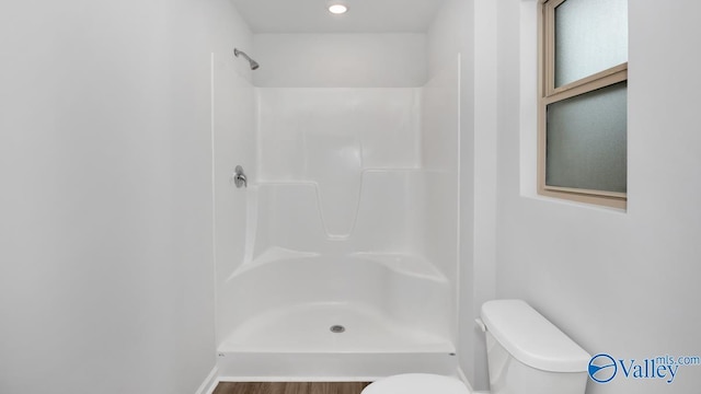 bathroom featuring walk in shower and toilet