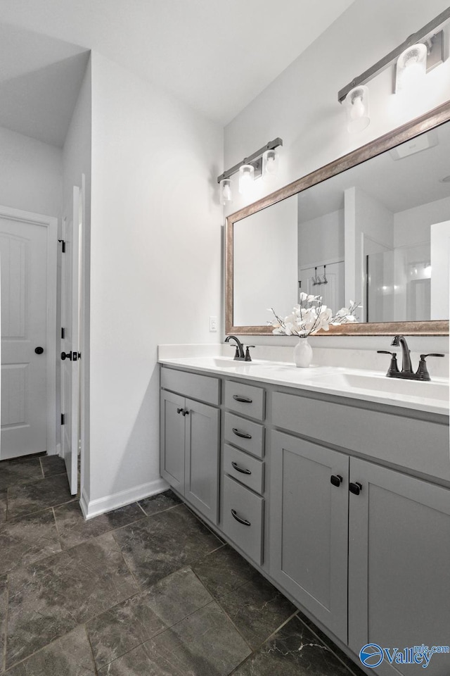 full bathroom with a sink, baseboards, and double vanity