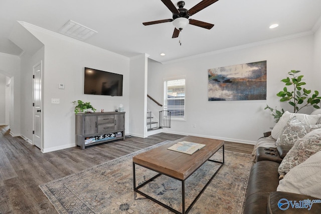 living area featuring ornamental molding, stairway, baseboards, and wood finished floors