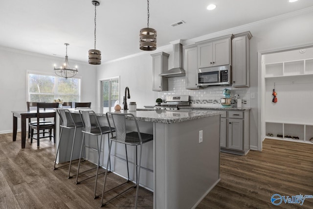 kitchen with visible vents, appliances with stainless steel finishes, backsplash, gray cabinets, and wall chimney exhaust hood