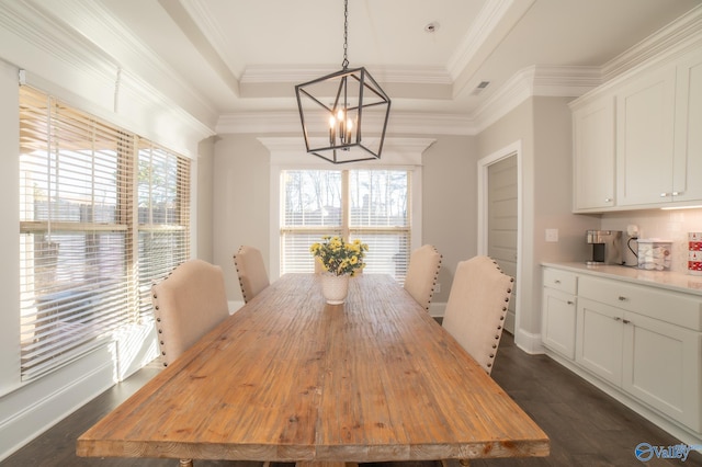 dining area featuring a raised ceiling, crown molding, and dark wood-type flooring