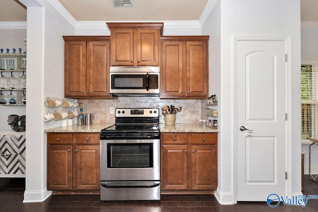 2906 Pasture View Ln, Owens Cross Roads, AL 35763 - kitchen featuring stainless steel appliances, light stone countertops, backsplash, brown cabinetry, and crown molding