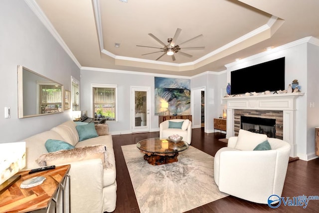 2906 Pasture View Ln, Owens Cross Roads, AL 35763 - living room with a tray ceiling, ceiling fan, a stone fireplace, ornamental molding, and wood finished floors