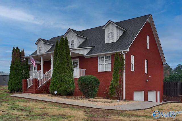 cape cod-style house with a porch and a garage