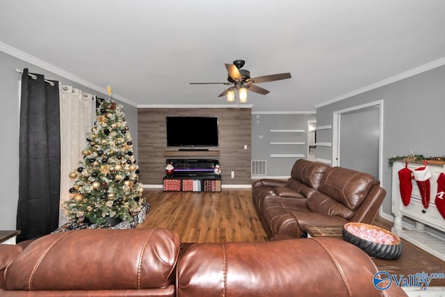 living room featuring ceiling fan, wood-type flooring, and ornamental molding