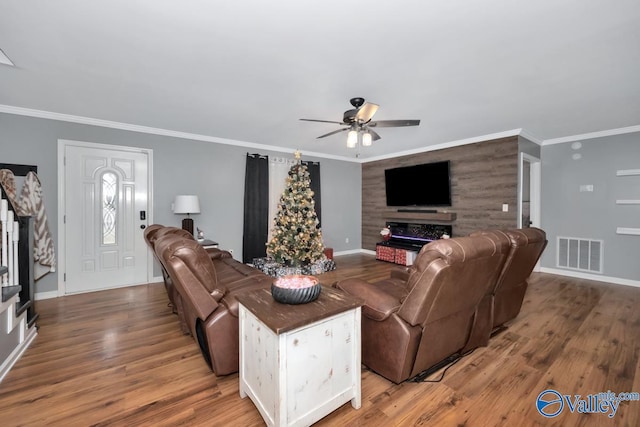 living room with wood-type flooring, ceiling fan, and ornamental molding