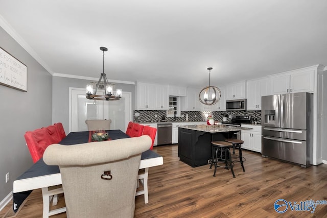 12956 Hickory Hills Rd, Athens, AL 35614 - dining room with dark hardwood / wood-style flooring, crown molding, and an inviting chandelier