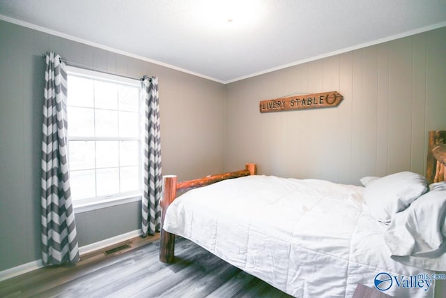 bedroom featuring hardwood / wood-style floors and ornamental molding