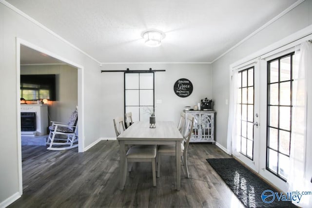 dining space with dark wood-type flooring, ornamental molding, a textured ceiling, french doors, and a barn door