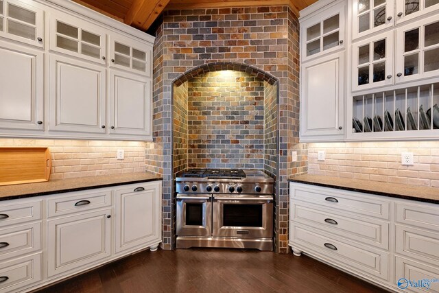 kitchen featuring white cabinets, beam ceiling, range with two ovens, and dark hardwood / wood-style flooring