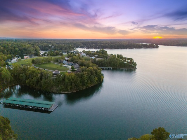 aerial view at dusk featuring a water view