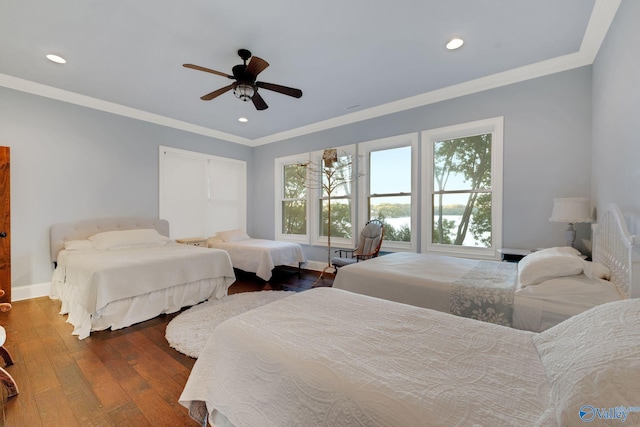 bedroom with crown molding, dark hardwood / wood-style floors, and ceiling fan