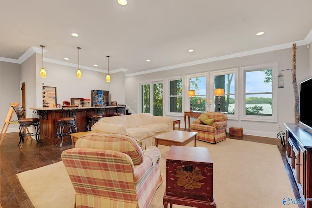 living room with ornamental molding, wood-type flooring, bar area, and plenty of natural light