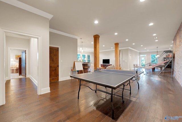 rec room with crown molding, dark hardwood / wood-style floors, and decorative columns