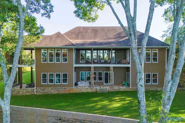 rear view of property with a balcony, a yard, and a patio area