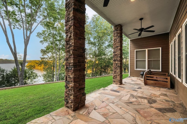 view of patio featuring a water view and ceiling fan