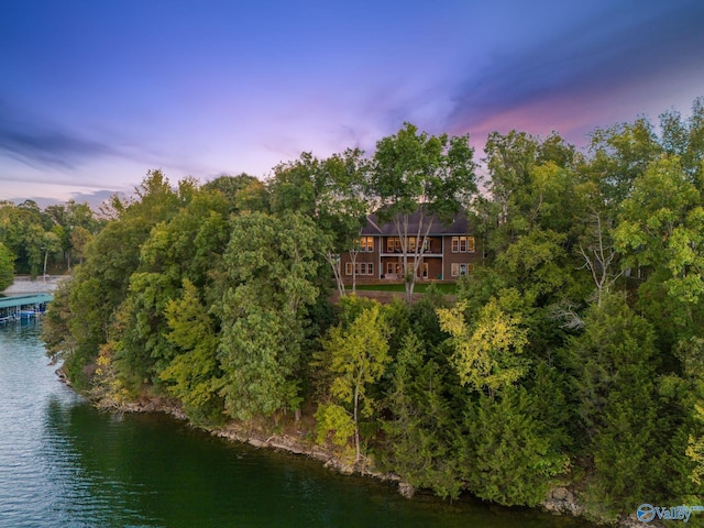 aerial view at dusk featuring a water view