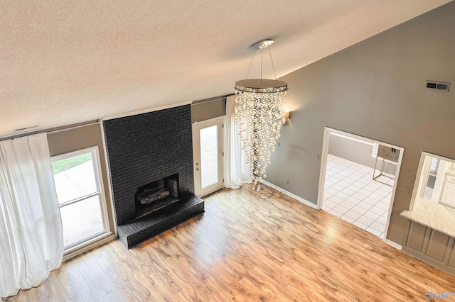 1509 Southampton Ct, Decatur, AL 35601 - unfurnished living room with wood finished floors, a textured ceiling, baseboards, and a brick fireplace