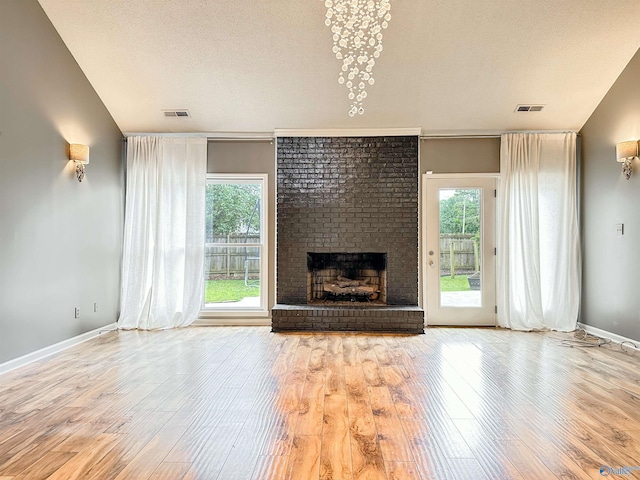 1509 Southampton Ct, Decatur, AL 35601 - unfurnished living room featuring a brick fireplace, wood finished floors, baseboards, and a textured ceiling